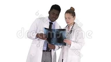 年轻的女医生和美国黑人医生看着白色背景下肺的x射线照片。